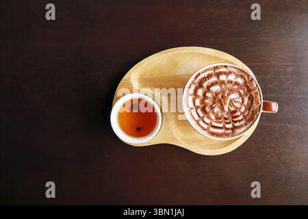 Es ist eine Tasse Kaffee und Tee auf Holzteller. Stockfoto