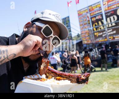 Toronto, Kanada. Juni 2025. Ein Mann genießt gegrillte Rippchen während des Toronto Ribfests 2025 in Toronto, Kanada, am 29. Juni 2025. Hier findet vom 28. Juni bis zum 1. Juli das jährliche Fleischliebesfest statt. Quelle: Zou Zheng/Xinhua/Alamy Live News Stockfoto