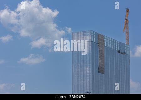 Ein Baukran schwebt über einem größtenteils fertiggestellten Hochhaus in Atlanta. Stockfoto