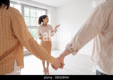 Eine Immobilienmaklerin zeigt einem Paar neues Haus Stockfoto