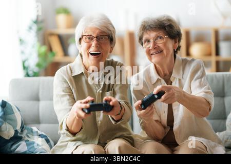 Zwei ältere Freundinnen oder Schwestern spielen zu Hause Videospiele. Stockfoto