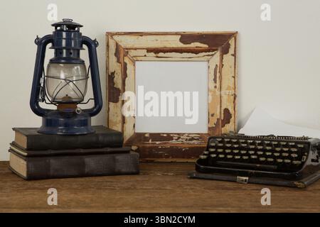 Bilderrahmen, Laterne und Schreibmaschine auf dem Tisch Stockfoto