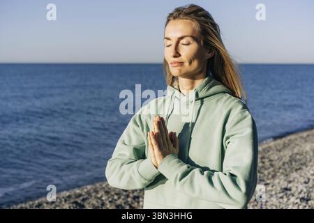 Nahporträt einer Frau, die am Meer meditiert Stockfoto