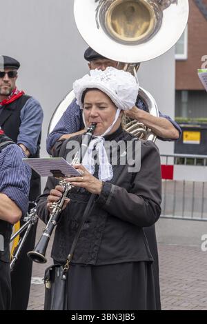 Barneveld, Niederlande - 1. August 2024: Frau in traditioneller Kleidung spielt Klarinette in einer Blaskapelle auf dem Veluwe-Markt während der Sommermonate in Stockfoto