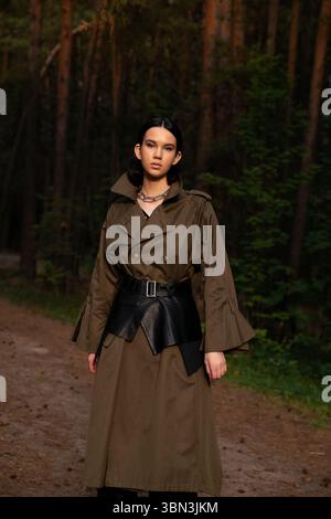 Junge Frau in braunem Anzug im Wald Stockfoto