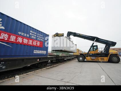 Peking, China. 30. Juni 2025. Ein Kran lädt einen Container auf einen China-Europa-Güterzug im Pekinger Internationalen Landhafen im Bezirk Fangshan in Peking, Hauptstadt Chinas, am 30. Juni 2025. Eine neue Güterzugstrecke China-Europa, die Peking mit Baku von Aserbaidschan verbindet, wurde am Montag gestartet. Mit dem multimodalen Transport „Schiene-See-Schiene“ soll die Nutzlast per Schiff über das Kaspische Meer gelangen und in 15 Tagen in Baku ankommen. Quelle: Zhang Chenlin/Xinhua/Alamy Live News Stockfoto