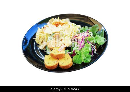 Es ist Carbonara Spaghetti mit Knoblauchbrot und Salat auf schwarzer Platte isoliert auf weiß. Stockfoto