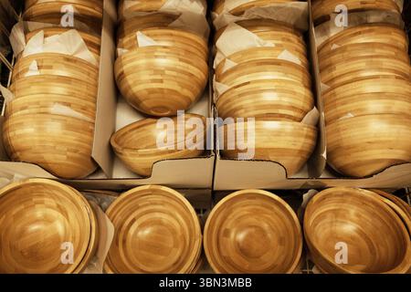 In Boxen angeordnete, stapelbare Bambusschalen mit natürlicher Holzstruktur und glatter Handwerkskunst. Das Schaufenster einer Haus- und Küchenartikel St Stockfoto