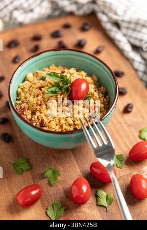 Hausgemachter Couscous-Salat mit frischen Kirschtomaten, serviert auf einer Schüssel. Stockfoto