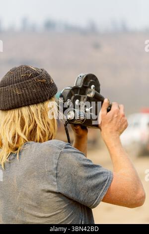 Kameramann filmt mit einer alten Filmkamera in staubiger Landschaft Stockfoto