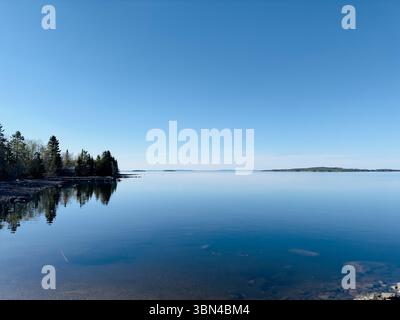 Der ruhige See spiegelt den atemberaubenden blauen Himmel und die umliegende Landschaft wider. Stockfoto