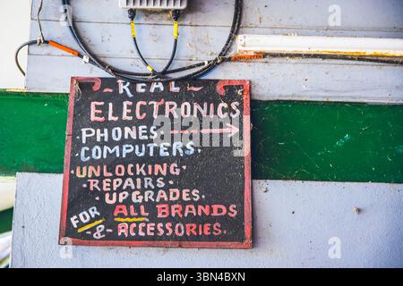 Antigua und Barbuda, Westindien, Antigua Island. St. John's, Verkäufer und Reparaturwerkstatt von elektronischen Computergeräten auf dem Markt Stockfoto