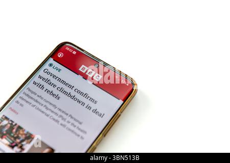 London. UK- 06.27.2025. Ein Mobiltelefon mit der Anwendung BBC New auf dem Bildschirm isoliert auf weißem Hintergrund. Stockfoto