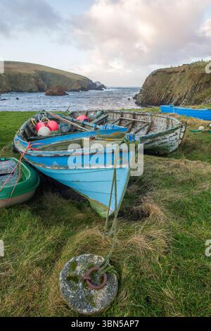 Die verwitterten Shetland-Yal-Boote ruhen ruhig am Peerie Spiggie Beach und spiegeln das stolze maritime Erbe und die traditionelle Handwerkskunst der Inseln wider. Stockfoto