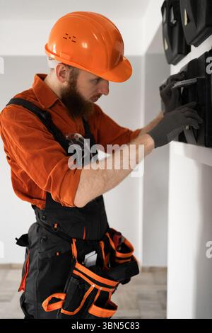 Ein bärtiger Elektriker arbeitet auf der Baustelle mit einer Schalttafel. Kopierbereich Stockfoto