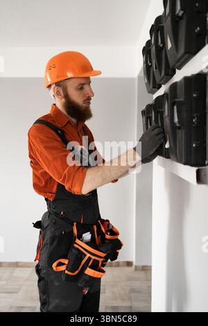 Ein bärtiger Elektriker arbeitet auf der Baustelle mit einer Schalttafel. Kopierbereich Stockfoto