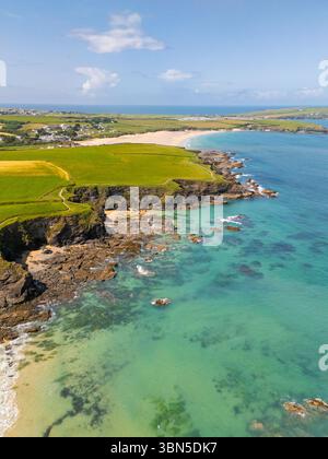Ein Blick aus der Vogelperspektive fängt die malerische Schönheit einer Küste ein, wo türkisfarbenes Wasser auf felsige Küsten und grüne Felder trifft und die natürliche Landschaft zeigt. Stockfoto