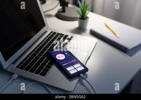 Laden des Telefons, vom Laptop aus. Telefonaufladekonzept Stockfoto