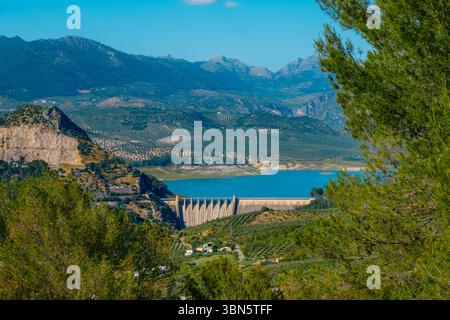 Der Iznajar-Damm steht im Vordergrund dieser Luftaufnahme und hält das Wasser des Genil-Flusses in der Provinz Cordoba auf einem hellen Stockfoto