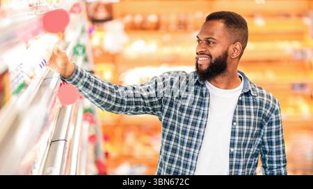 African Male Doing Shopping Stehen In Der Nähe Regal Im Lebensmittelgeschäft Stockfoto