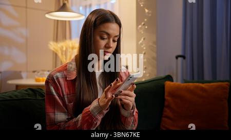 Frau, die Handy online einkaufen zu Hause Abend Nacht Kaukasisches Mädchen weibliche Benutzer Studentin Geschäftsfrau Teenager Chat Dating App Stockfoto
