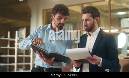 Kaukasische Männer Geschäftskollegen Geschäftsleute streiten über Dokumente Firmenpapiere Bankgeschäfte Missverständnis zwei professionelle Kollegen Stockfoto