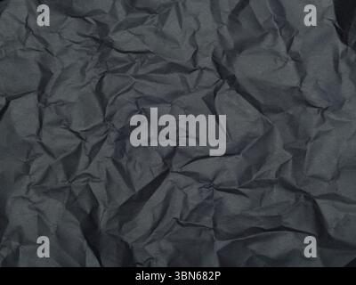 Textur von zerknittertem dunkelgrauem Papier. Hintergrund. Stockfoto