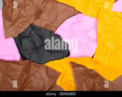 Lebendige Collage aus zerknitterten Papierresten in verschiedenen Farben, darunter Braun, Rosa, Schwarz und Gelb. Hintergrund. Stockfoto