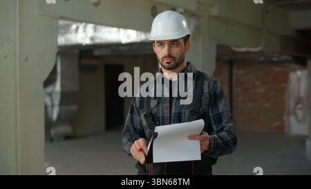Baumeister Architekt Ingenieur Mann inspiziert Gebäude auf der Baustelle Reparaturarbeiten Problem unzufriedener Vorarbeiter, der Checkliste schreibt Hispanic Guy Stockfoto
