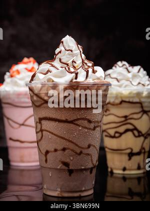 Schokoladenmilchshake in einem klaren Glas auf dunklem Hintergrund serviert. Isoliertes Getränk. Stockfoto