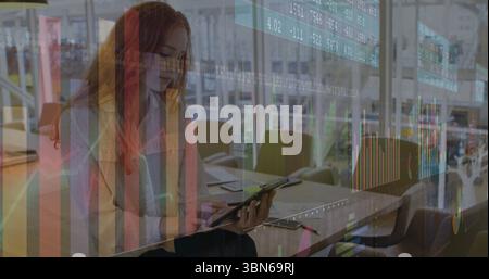 Mit Tablette und Stift, Frau in gepunkteter Bluse, die im Großbüro Finanzpläne studiert Stockfoto