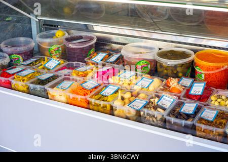 Eine bunte Ausstellung von eingelegtem und fermentiertem Gemüse wird in einem gekühlten Vitrine auf einem Markt ausgestellt. Krasnodar, Russland - 11.03.2025 Stockfoto