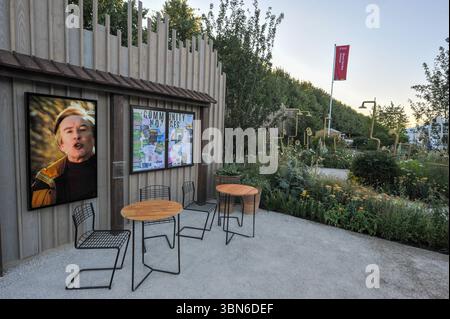 Eröffnungstag beim 2025 Royal Horticultural Society Hampton Court Palace Garden Festival - einer der Ausstellungsgärten: Der Alan Partridge Sound Bath Garden. Dieser moderne Garten wurde von Alan Partridge mit Top-Designern entworfen und zelebriert Struktur, Haltbarkeit und persönliche Bedeutung. Ein herausragendes Merkmal ist ein Norfolk-Lärchenzaun, der mit Alans Namen in Schallwellenform geätzt ist. Goldschmiedearbeiten, inspiriert von den Subaru GC8 Laufrädern, und robuste britische Materialien spiegeln Alans akribische Standards wider. Jedes Element – von recycelten Schildern bis hin zu handgefertigten Dartmoor-Eichenpfosten – verkörpert Funktionalität und Präzision Stockfoto