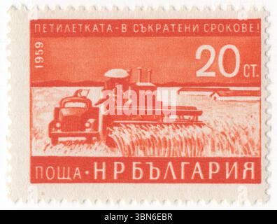 BULGARIEN — 1959: Eine 20-stotinki-orange Briefmarke, die Mähdrescher darstellt. Frühzeitige Fertigstellung des Fünfjahresplans (1959). Mähdrescher, ist eine Maschine, die für die Ernte einer Vielzahl von kultiviertem Saatgut entwickelt wurde. Mähdrescher sind eine der wirtschaftlich wichtigsten arbeitssparenden Erfindungen, die den Anteil der in der Landwirtschaft tätigen Bevölkerung deutlich reduzieren. Zu den mit einem Mähdrescher geernteten Kulturen gehören Weizen, Reis, Hafer, Roggen, Gerste, Mais (Mais), Sorghum, Hirse, Sojabohnen, Leinsamen, Sonnenblumen und Rapssamen (Canola) Stockfoto
