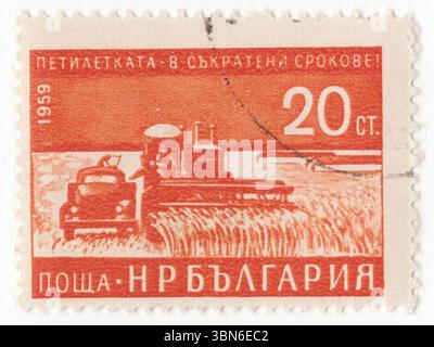 BULGARIEN — 1959: Eine 20-stotinki-orange Briefmarke, die Mähdrescher darstellt. Frühzeitige Fertigstellung des Fünfjahresplans (1959). Mähdrescher, ist eine Maschine, die für die Ernte einer Vielzahl von kultiviertem Saatgut entwickelt wurde. Mähdrescher sind eine der wirtschaftlich wichtigsten arbeitssparenden Erfindungen, die den Anteil der in der Landwirtschaft tätigen Bevölkerung deutlich reduzieren. Zu den mit einem Mähdrescher geernteten Kulturen gehören Weizen, Reis, Hafer, Roggen, Gerste, Mais (Mais), Sorghum, Hirse, Sojabohnen, Leinsamen, Sonnenblumen und Rapssamen (Canola) Stockfoto