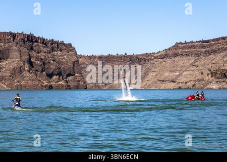 Cove Palisades State Park, Oregon, USA - 1. September 2018: Eine Person fliegt auf dem See, während andere Jetskis fahren. Stockfoto