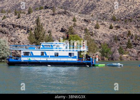 Cove Palisades State Park, Oregon, USA - 1. September 2018: Eine Gruppe genießt Wasseraktivitäten von einem Hausboot aus, wobei eine Person ein Flyboard benutzt. Stockfoto