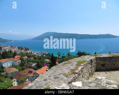 Besucher bewundern die atemberaubende Aussicht von der Kanli Kula Festung in Herceg Novi, einer historischen Stätte mit einer reichen Vergangenheit und einer atemberaubenden Landschaft der Bucht von Kotor. Stockfoto