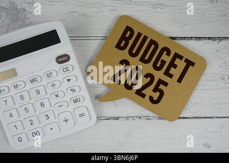 Haushaltstext 2025 mit Rechner auf hölzernem Hintergrund Stockfoto
