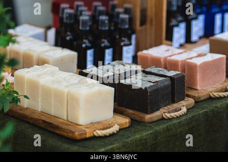 Handgefertigte Bio-Seifenstangen auf Holzbrettern zum Verkauf auf einer Volksmesse oder einem Markt für Kunsthandwerk Stockfoto