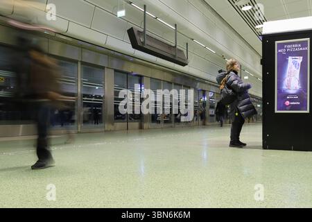 Ruhige entspannende Frau in der Hauptverkehrszeit an einer U-Bahn-Station. Verschwommene Leute in Eile im Hintergrund. Odenplan, zentraler Teil der schwedischen Hauptstadt. Stockfoto