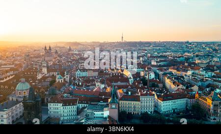 Ein wunderschöner Blick aus der Luft fängt die Altstadt von Prag ein, die in warmes Morgenlicht getaucht ist. Die bezaubernden Dächer, historischen Gebäude und die Moldau schaffen ein atemberaubendes Panorama. Stockfoto