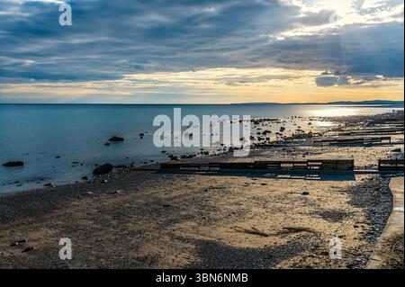 Blick auf den Weststrand bei Sonnenuntergang auf Criccieth, Wales im Frühling Stockfoto