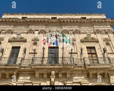 Eine Nahaufnahme der kunstvollen Fassade des Palazzo Vermexio in Ortigia, Syrakus - ein wunderschönes Beispiel barocker Architektur, reich an Details und Charakter. Stockfoto