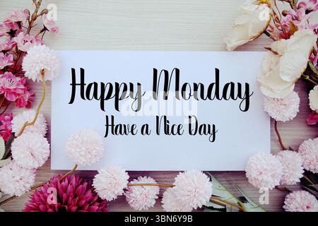 Happy Monday haben Einen schönen Tag Text mit Blumendekorationen auf hölzernem Hintergrund Stockfoto