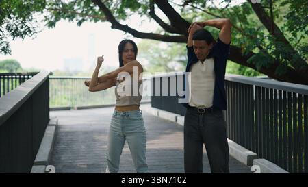 Mann und Frau wärmen sich zusammen auf, bevor sie draußen trainieren Stockfoto