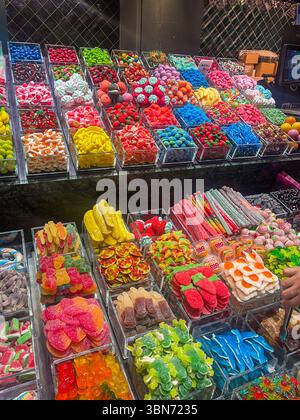 Barcelona, Spanien - 11. Juli 2024: Mercat de la Boqueria, überdachter Marktplatz. Körbe mit bunten Süßigkeiten, bereit zum Verzehr, ausgestellt Stockfoto