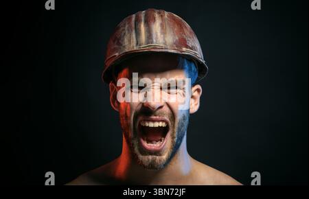 Nahaufnahme Porträt eines wütenden Architekten, Vorarbeiters oder Baumeisters mit Schutzhelm. Gutaussehender schreiender Ingenieur oder Bauarbeiter im Schutzhelm. Harte Arbeit. S Stockfoto