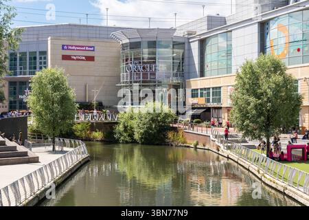 Shopper und Besucher des Oracle Indoor Shopping Centre & Freizeit Mall, überqueren den Fluss Kennet auf einer Fußgängerbrücke, Reading, Großbritannien Stockfoto