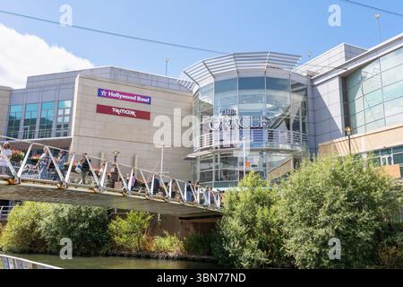 Shopper und Besucher des Oracle Indoor Shopping Centre & Freizeit Mall, überqueren den Fluss Kennet auf einer Fußgängerbrücke, Reading, Großbritannien Stockfoto